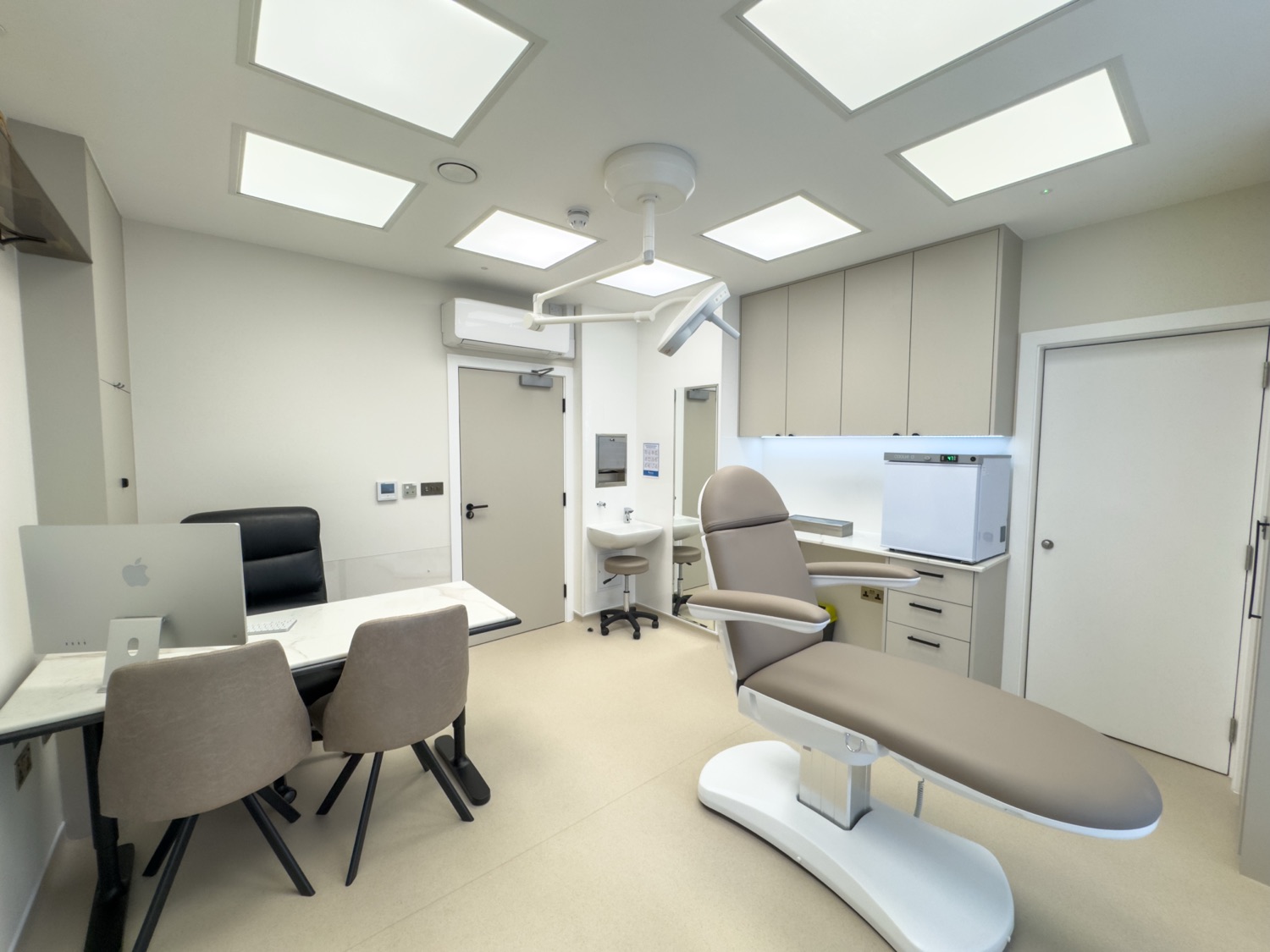 Consultation room at Kensington Cosmetic Clinic with marble desk and electric fireplace