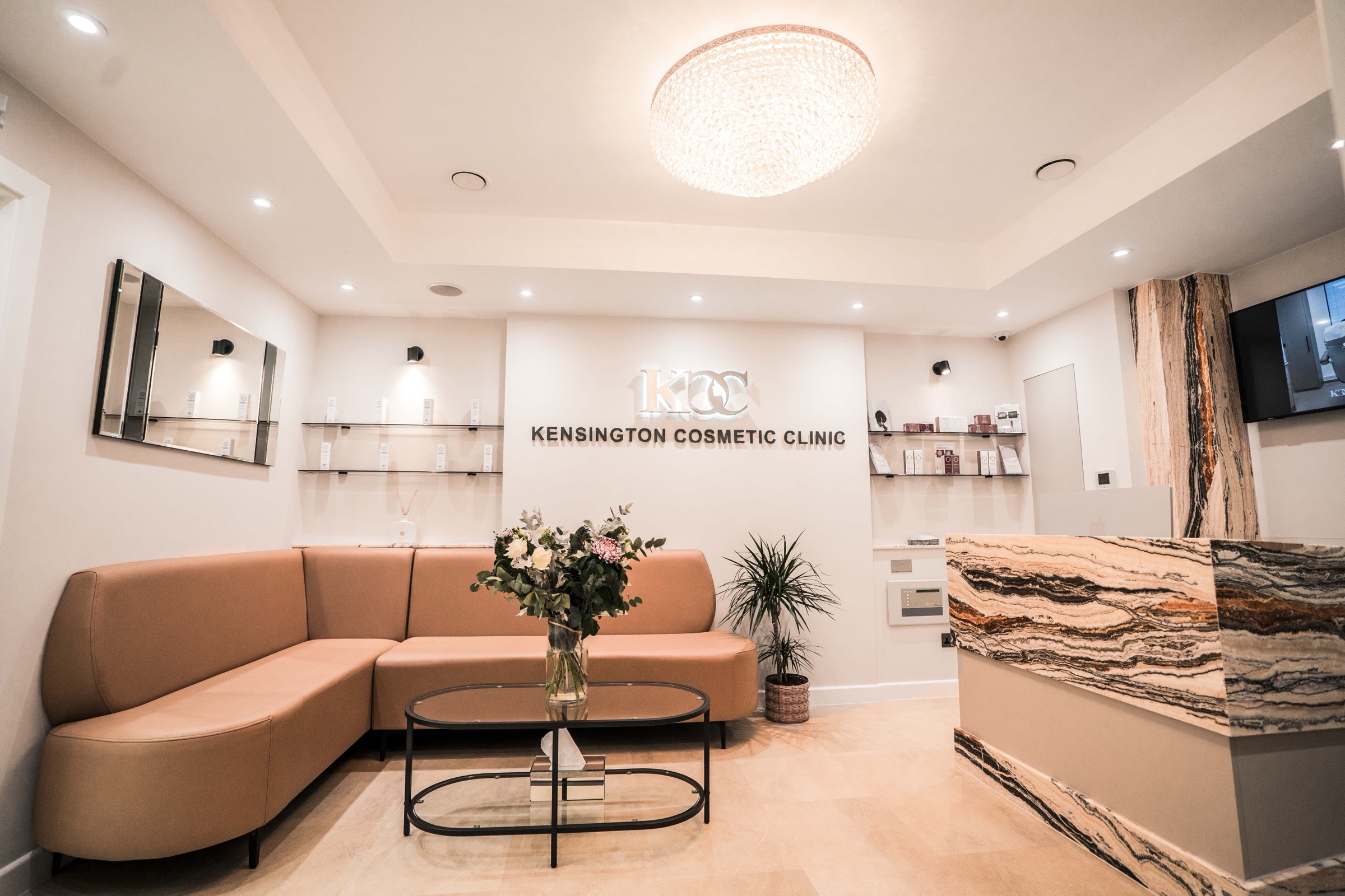 Kensington Cosmetic Clinic reception with KCC logo wall