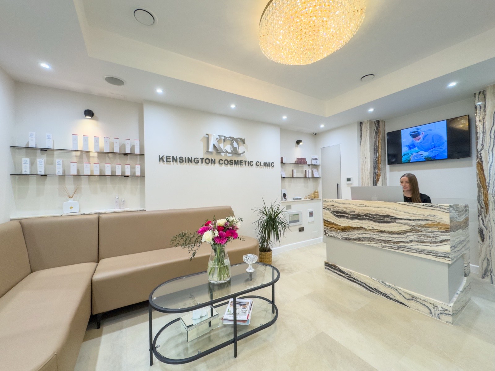 Kensington Cosmetic Clinic reception with KCC logo wall